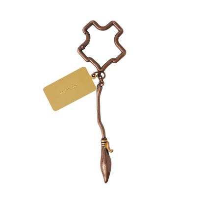 Bronze Nimbus 2000 keychain with a Hogwarts crest-shaped holder and gold tag on a white background