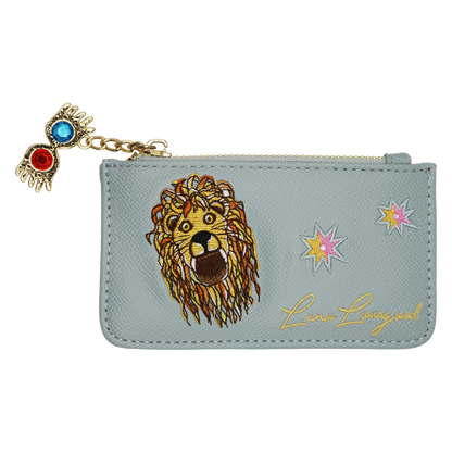 A light blue faux leather zippered pouch featuring a large embroidered lion face, two star motifs, gold cursive 'Luna Lovegood' script, and a dangling Spectrespecs charm with red and blue stones on a gold chain.