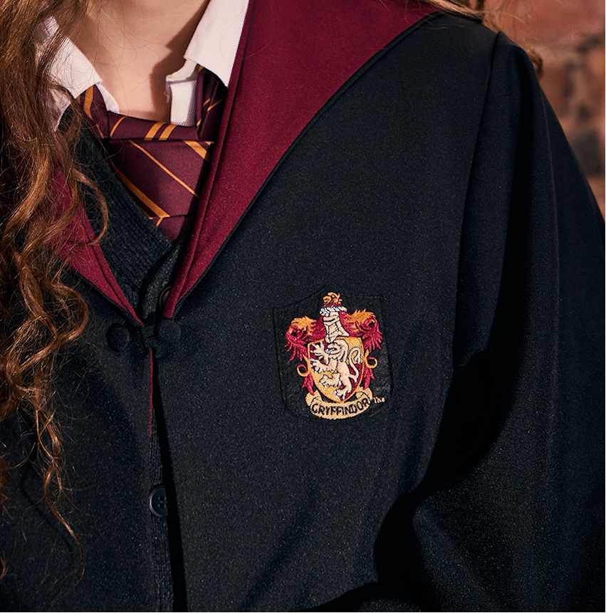GIF of a model wearing a Gryffindor house robe featuring the Gryffindor house crest and the name 'Maya' embroidered in gold text