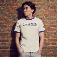 Person wearing a 'Quidditch' t-shirt against a brick wall
