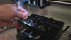 Video of a machine engraving the Hogwarts Express Acceptance Letter charm and a person holding up the finished engraved product